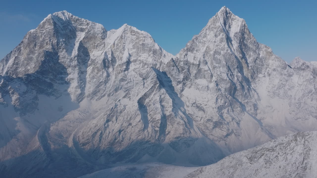 Gliding aerial drone shot of Everest Base Camp in Khumbu, Nepal. Morning snowfall reveals Khumbu Glacier and Cholatse Gokyo Peak in the Himalayas, a majestic spiritual vibration in Himalayas
