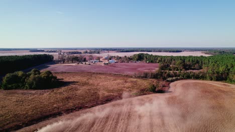 Vista-Aérea-De-Una-Cosechadora-En-Una-Tierra-De-Cultivo-De-Georgia,-Arando-Los-Campos-Durante-La-Temporada-De-Cosecha-De-Soja