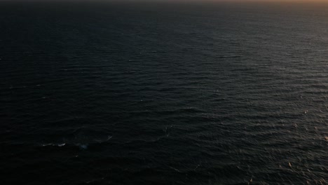 drone above ocean revealing epic cloud covered table mountain sunset silhouette