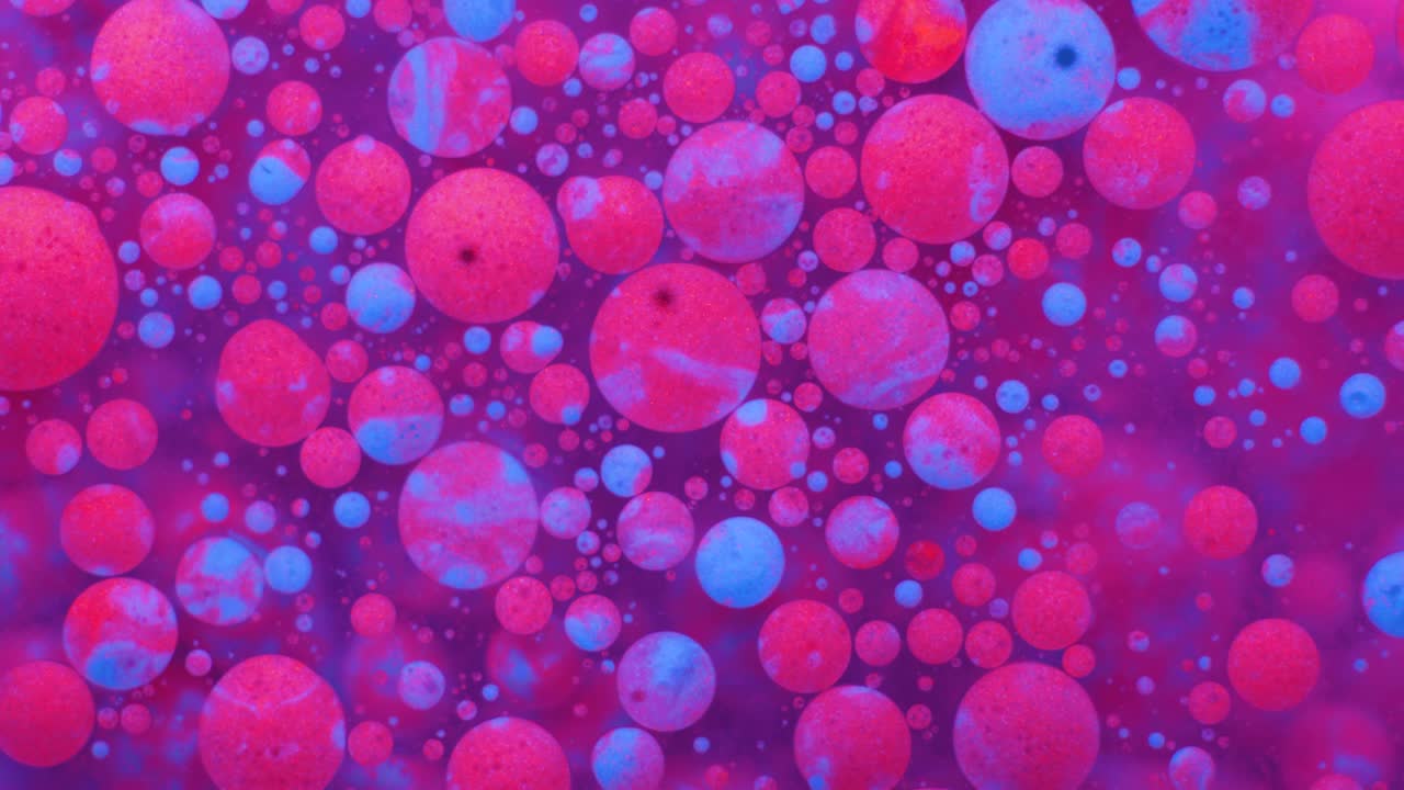 Slow Motion Bright Neon Color Bubbles Oil Beautiful Fluorescent Paint Sparkling Color Moving Multicolor Close up. Acrylic Neon Paint. Fantastic Surface. Abstract Colorful Transformation Gravitation.
