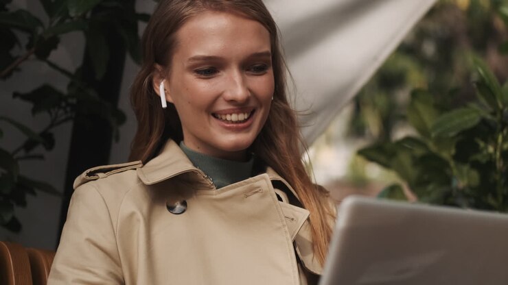 Femme caucasienne en visioconférence sur ordinateur portable en extérieur