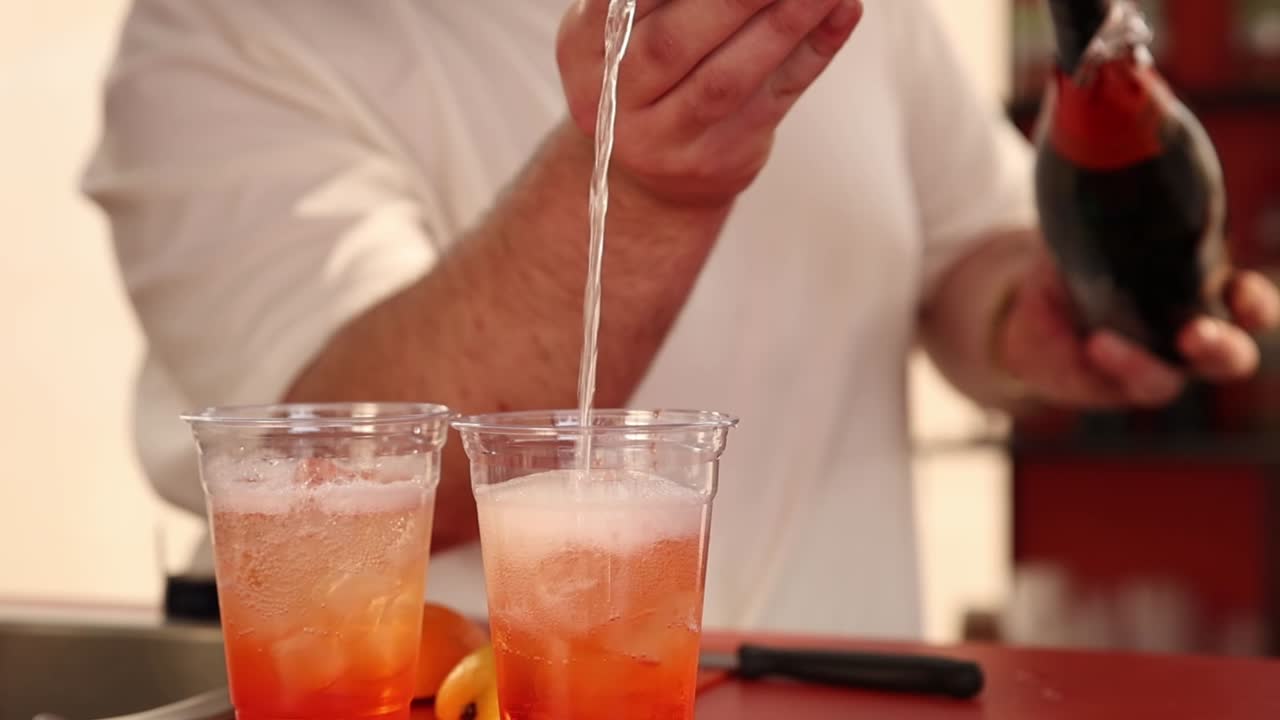 바텐더가 아페롤 스프리츠 테일을 준비하고 있습니다.