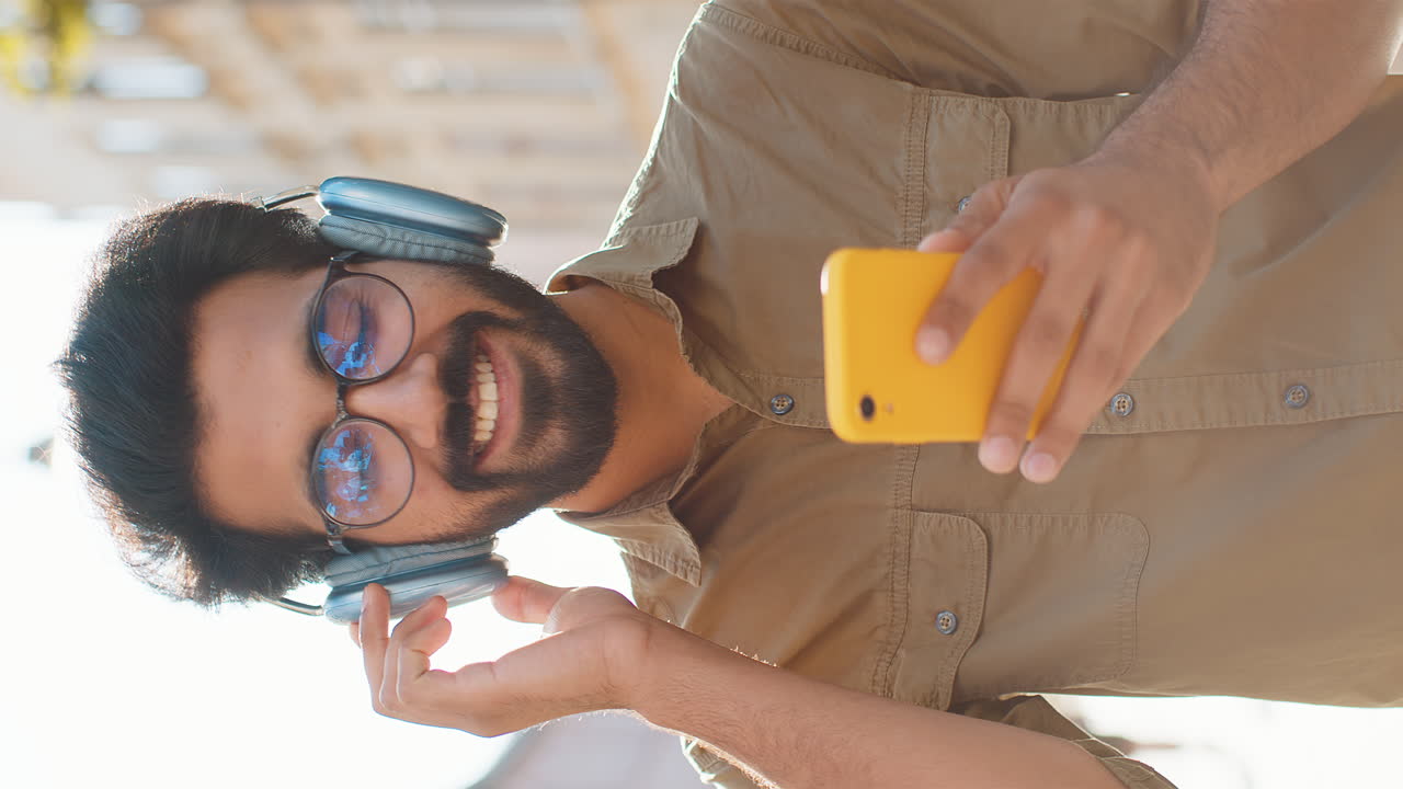 hombre usando teléfono inteligente y auriculares al aire libre