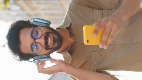 man using smartphone and headphones outdoors