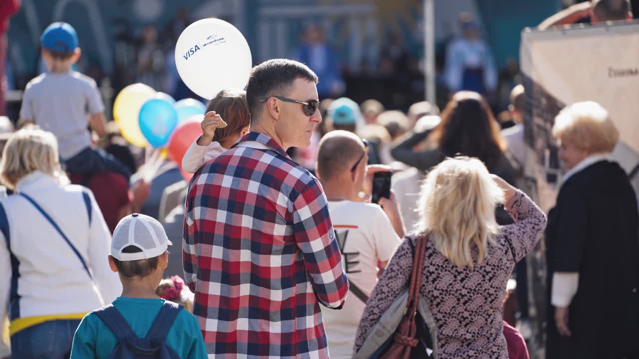 People on street during festival. Large crowd of people watching concert
