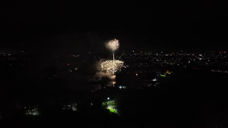 Aerial-tilting-shot-of-golden-fireworks-exploding-at-night-in-the-UK