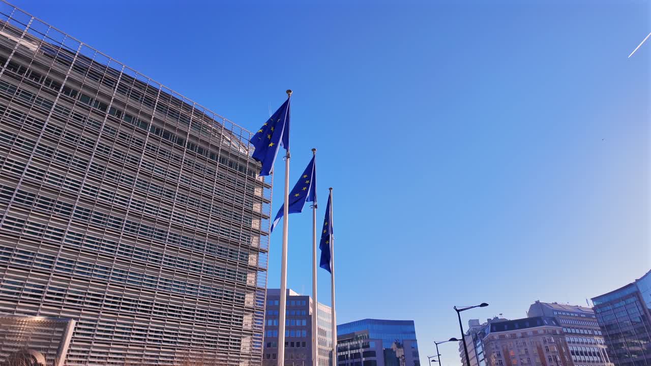 Low-angle shot of EU flags waving under a clear blue sky