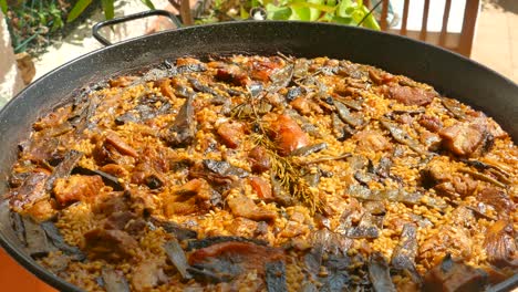 Close-up-shot-over-freshly-cooked-traditional-Spanish-dish-Paella-on-a-stove-with-mussels,-shrimp,-squid-and-rice-in-Valencia,-Spain-at-daytime