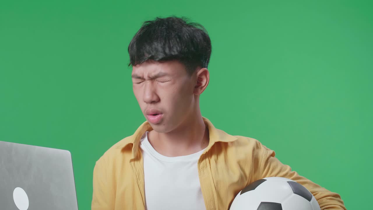 축구공과 노트북으로 혼란스러워 보이는 십대