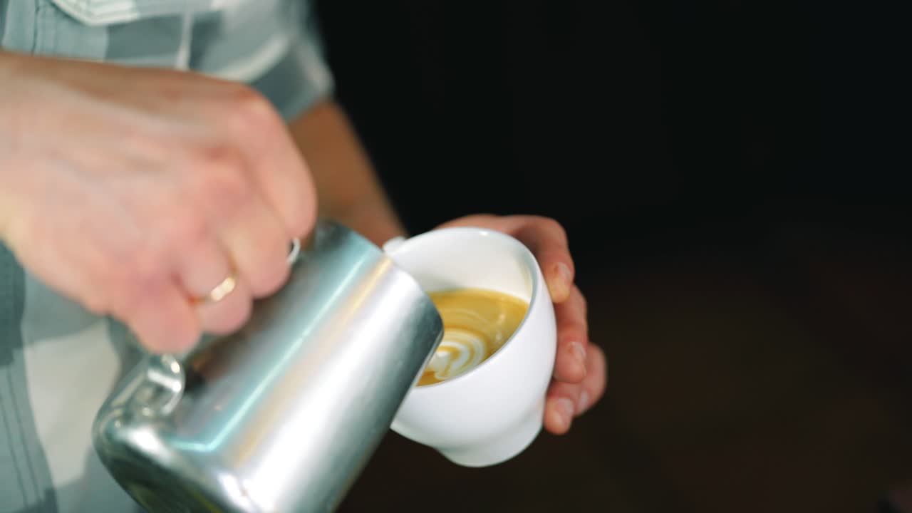 Barista pouring milk in coffee cup for making latte art.slow motion shot. Art of making cappuccino in a cup
