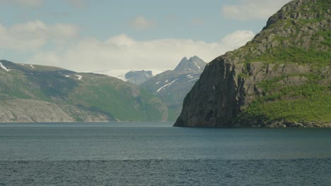 Vista-Panorámica-De-Un-Ferry-Que-Cruza-El-Círculo-Polar-ártico-En-Noruega-Con-Montañas-Al-Fondo