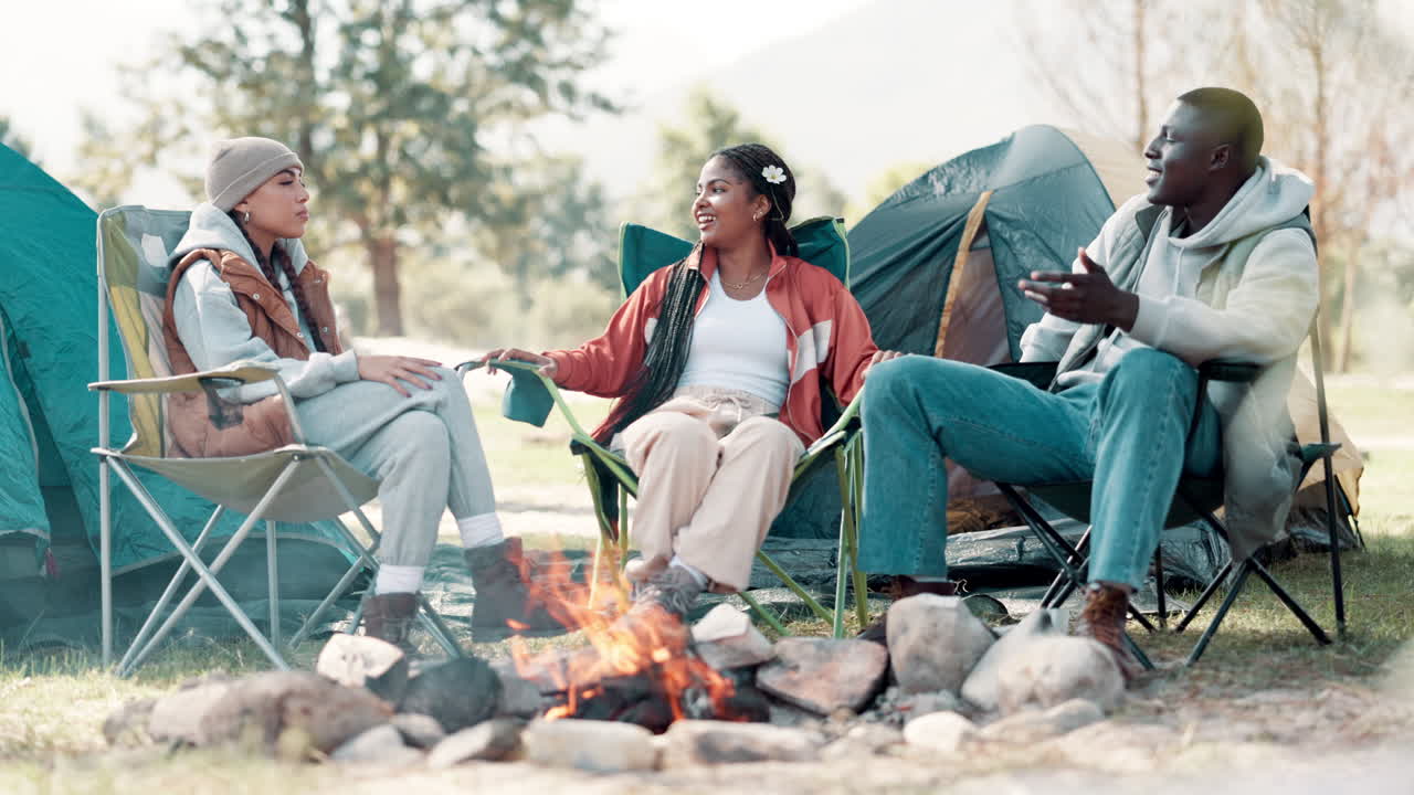 Friends camping around a campfire