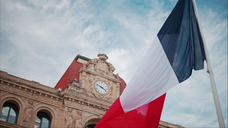 Bandiera francese che sventola di fronte al municipio (Mairie) di Cannes, Francia