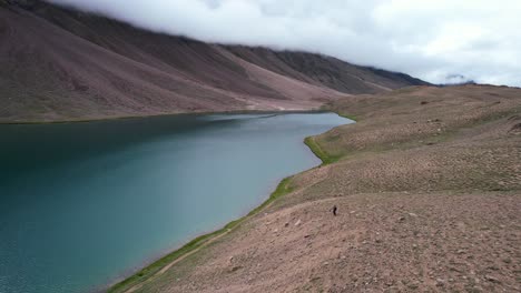 single-man-standing-at-Chandra-Taal-Lake-in-the-Himalaya-Mountains-of-India