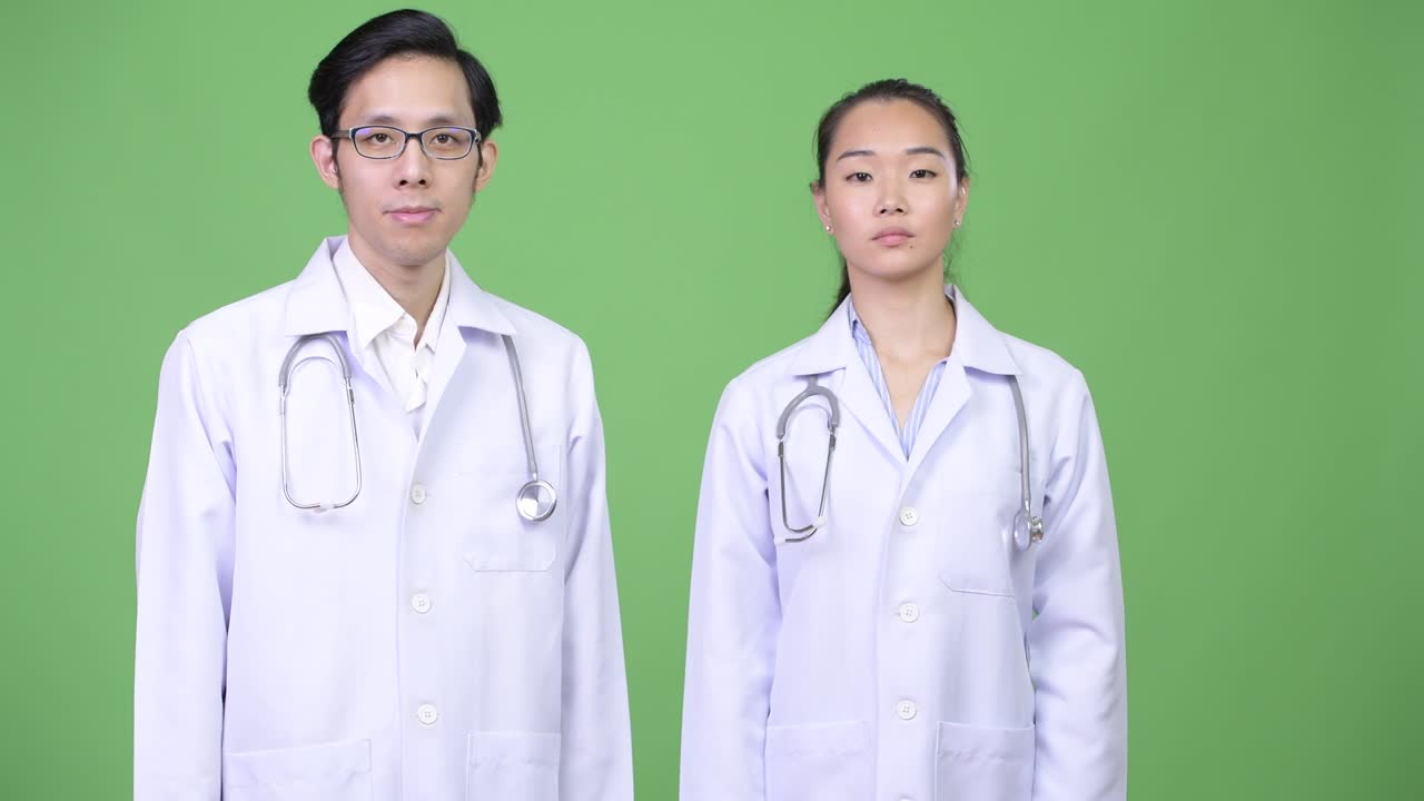 Young happy Asian couple doctors together