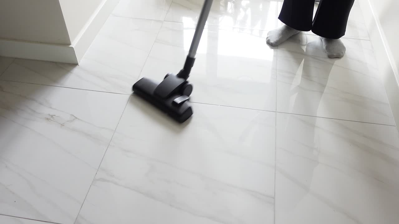 un aspirador limpia un piso de azulejos