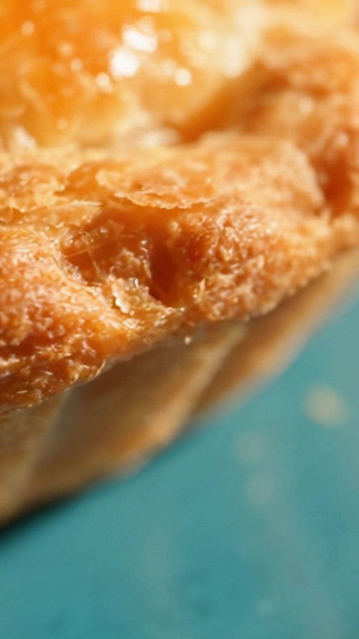 A Close-Up Look at the Flaky, Golden Crust of a Delicious Pastry Highlighting Its Texture and Color Against a Blue Background in Two Frames