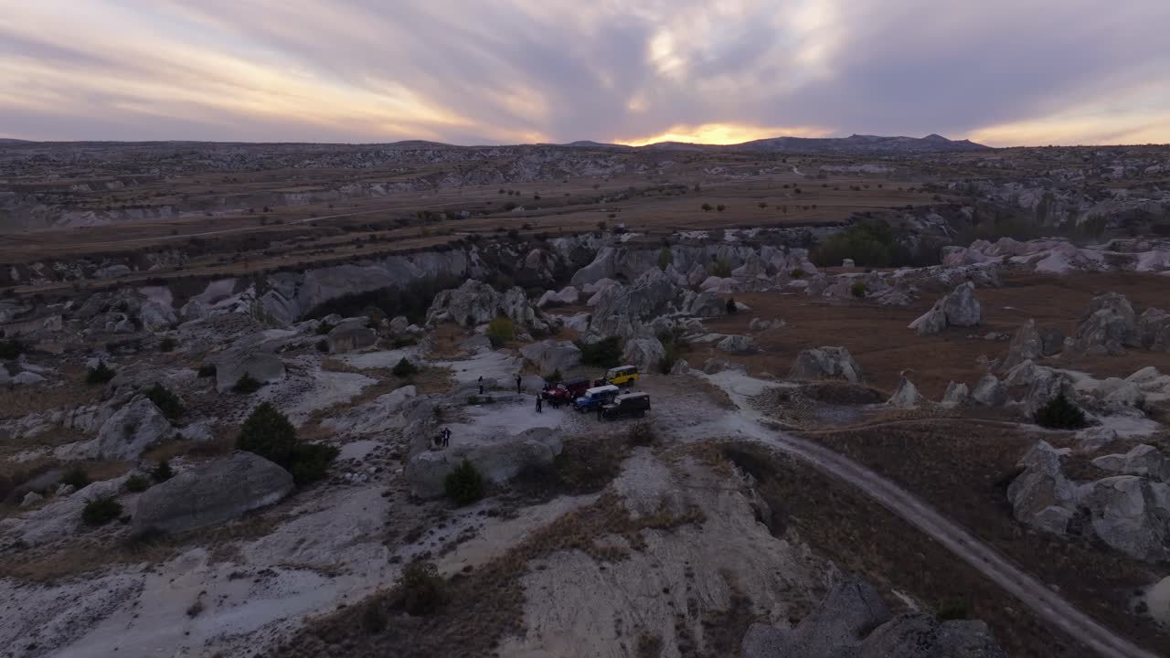 Vista aerea di fuoristrada 4x4 che esplorano una scoscesa valle rocciosa al tramonto, Ortahisar