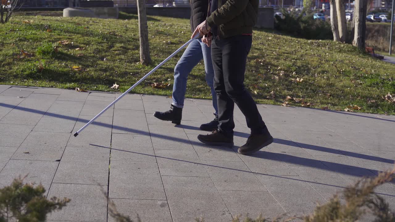 Blind man walking in the park with his wife.