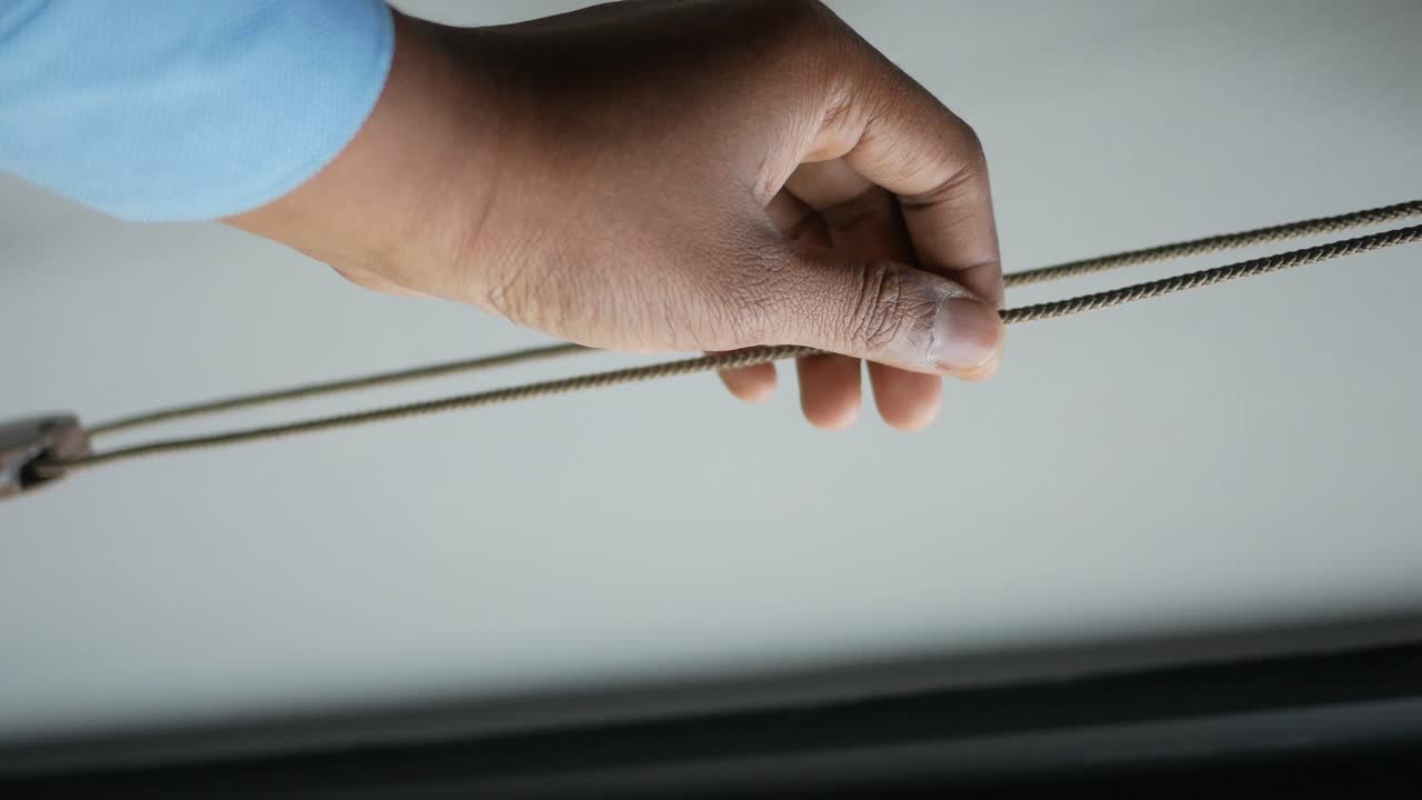 Person Adjusting a Window Blind Cord