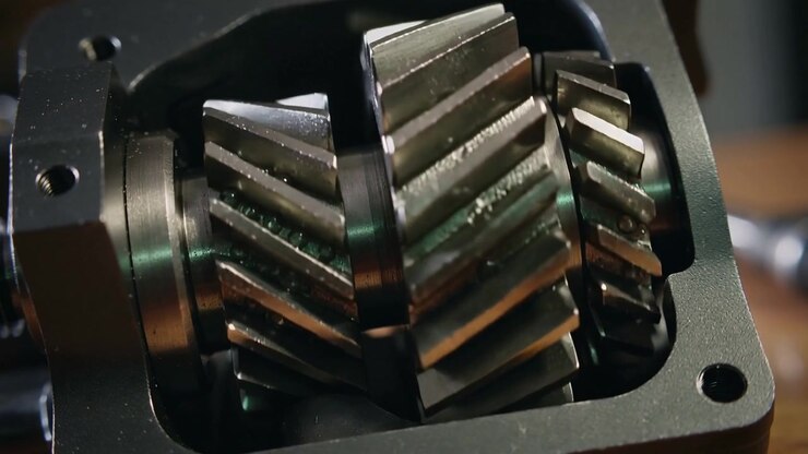 Rotating helical gear cluster showing slight clockwise movement for bench inspection, with oil film