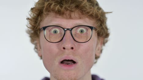 close up of face of shocked redhead young man