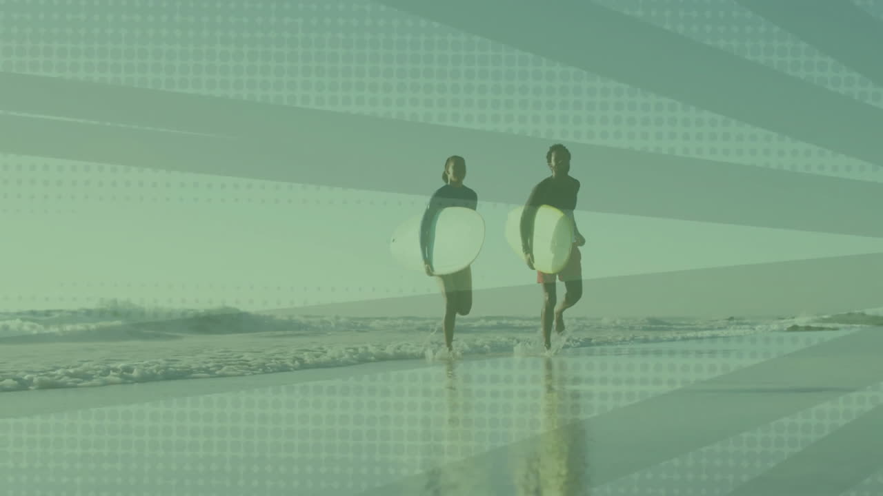 woman and man strolling wet sand carrying surfboards, showing animated tech graphs overhead