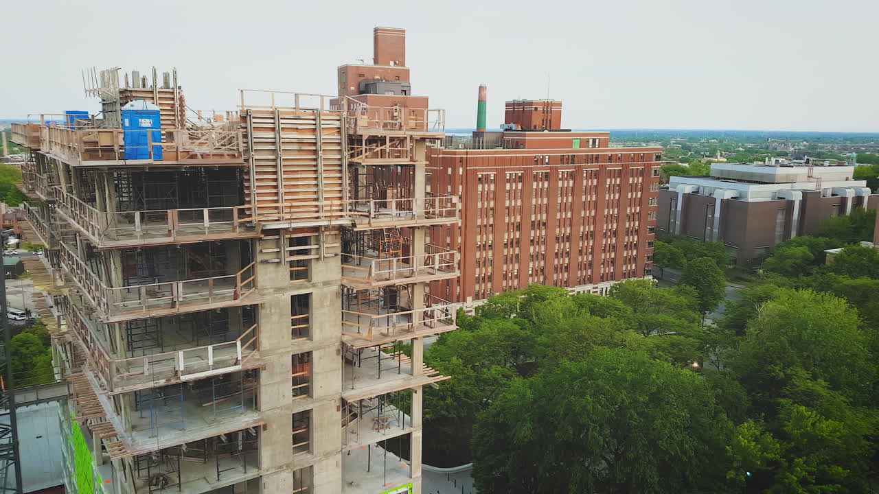 A large residential building under construction in a dense city