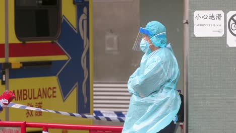 a police officer stands guard outside a public housing building placed under forced lockdown after a large number of residents tested covid-19 coronavirus positive