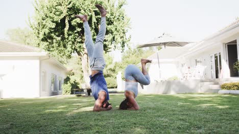 Feliz-Pareja-Caucásica-Practicando-Pose-De-Yoga-En-El-Jardín-Soleado,-Cámara-Lenta