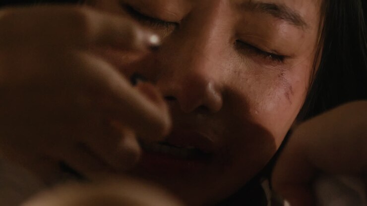 close up of young asiatic girl woman crying in fear while being physically abused and raped tortured chocked with a rope