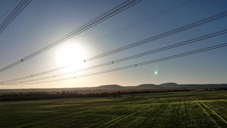 drone pulling back from powerlines then descending down