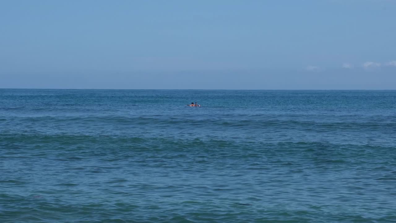 여름에 서핑보드에서 외로운 서퍼가 수영하는 바다 풍경