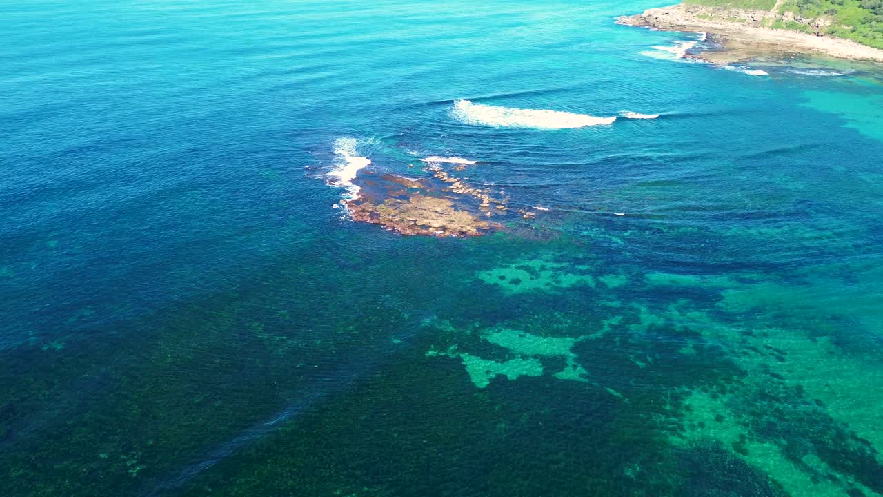 tomada aérea de drones de un arrecife oceánico transparente con rocas arenosas algas marinas hermoso día costa de la isla viajes turismo bahía de cuchara costa central nsw australia