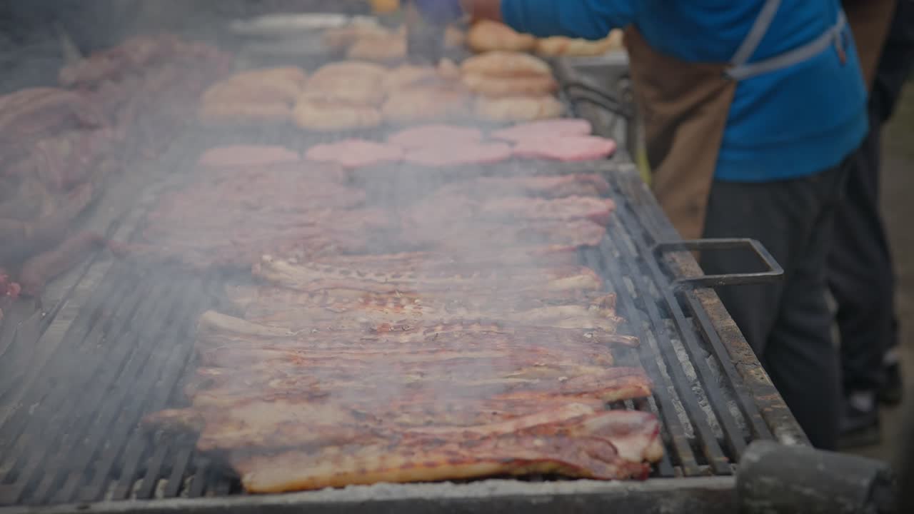 Festival atmosphere as feast of meats cook slowly on smoky BBQ grill