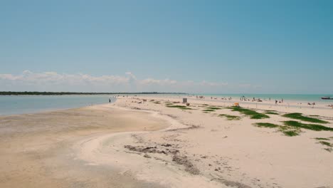 Volando-Bajo-Sobre-La-Gente-Disfrutando-Del-Verano-En-La-Larga-Playa-De-Arena,-Holbox