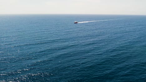 Aerial-drone-tracking-video-of-cruise-ship-in-deep-blue-open-Caribbean-sea,-Honduras