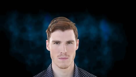 portrait of caucasian man looking to camera and breaking into smile, on dark blue background