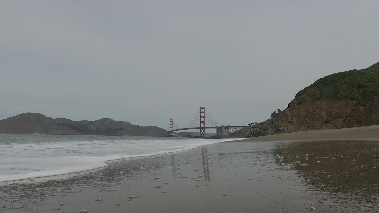 금문교 근처의 모래사장으로 굴러가는 독특한 파도