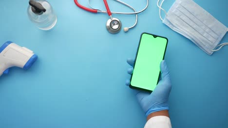 médico que utiliza un teléfono inteligente con suministros médicos