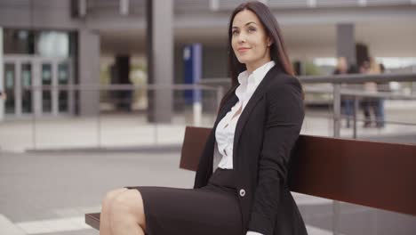 optimistic business woman sitting outdoors