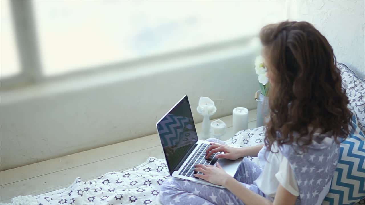 mujer joven trabajando en una computadora portátil en casa