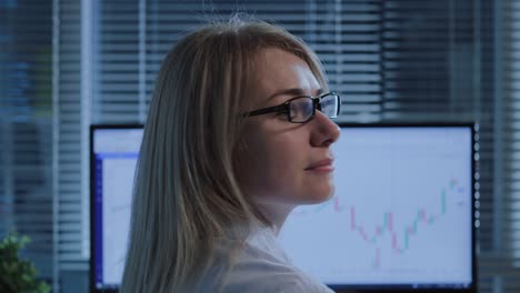 vista trasera de una mujer comerciante trabajando en la computadora y encendiendo la cámara en la oficina.