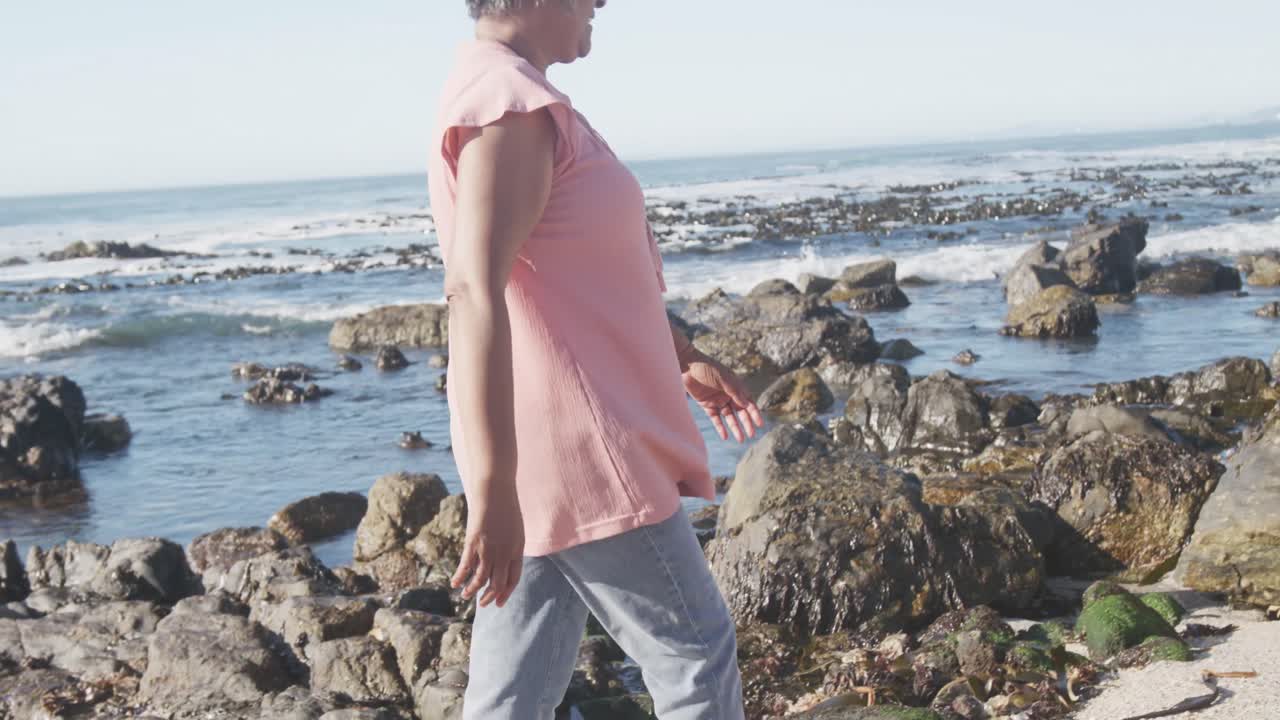 Anziana donna afroamericana che cammina in spiaggia, spazio per la copia, slow motion