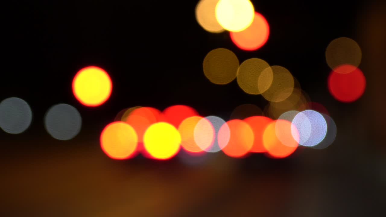 escena nocturna con luces borrosas de automóviles y semáforos