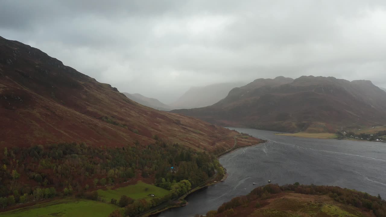 Aerial drone panoramic fly over shot. Beautiful Scotland highlands. Remote rural area, valley between mountains with a road winding through. 4k footage.