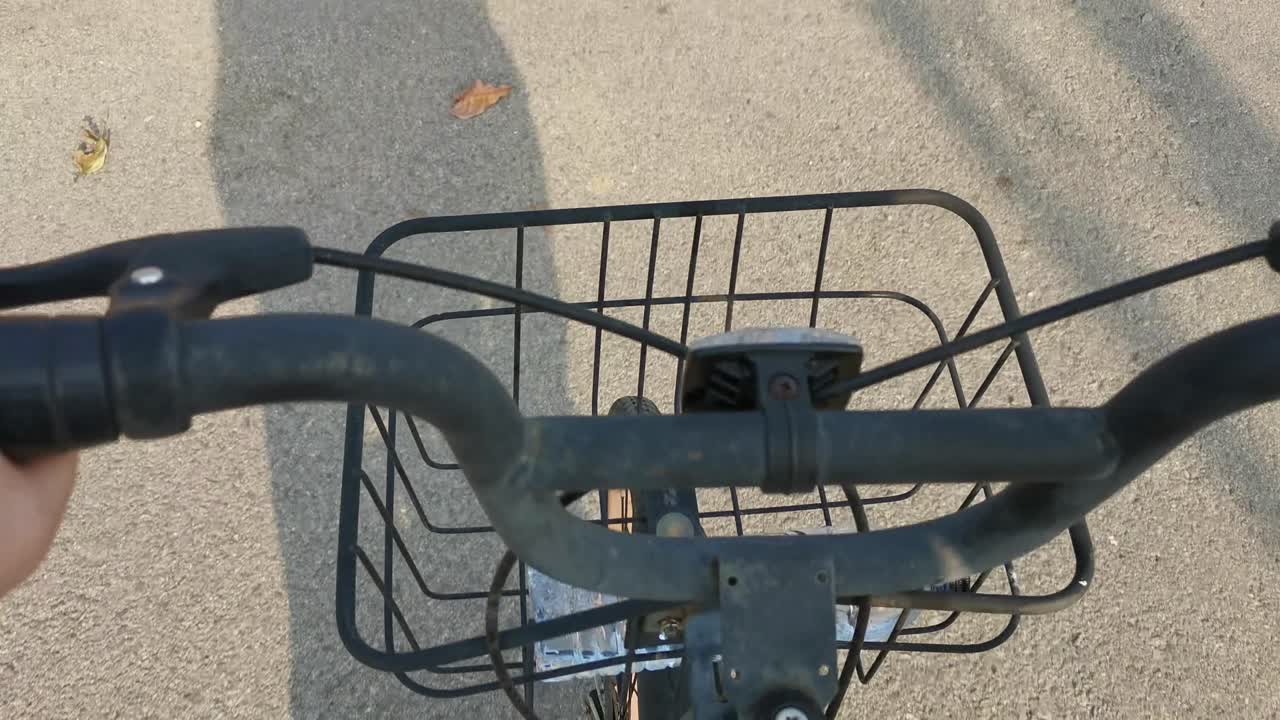 자전거 바구니 가 그림자 가 있는 도로 에서 앞으로 움직이는 모습