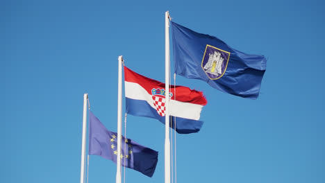 Banderas-Nacionales-De-La-Unión-Europea,-Croacia-Y-Una-Bandera-Local-Ondeando-En-El-Cielo