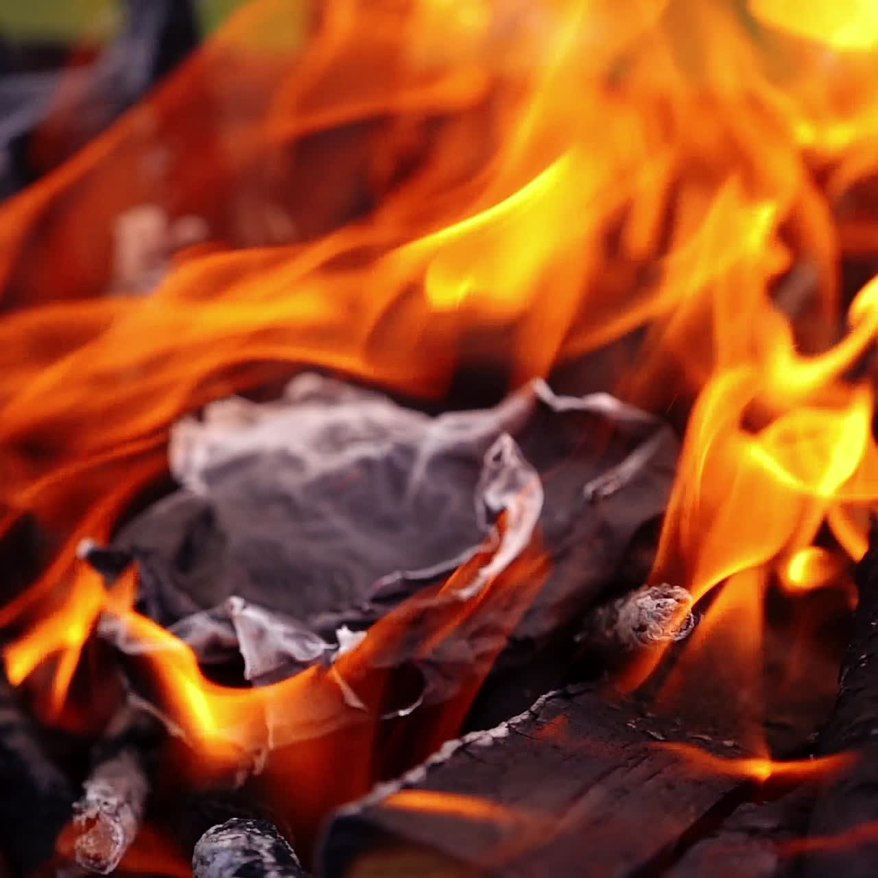 Orange flame moving. Wood is burning for barbecue. Twisting tongues of fire over the smoldering logs. Close-up. Slow motion.