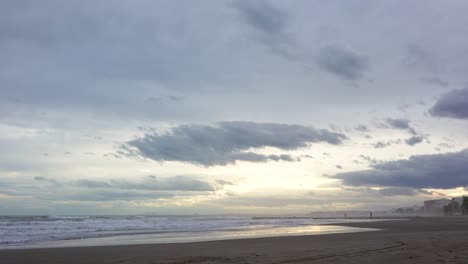 Couple-walks-on-breakwater-on-the-horizon-and-at-sunset